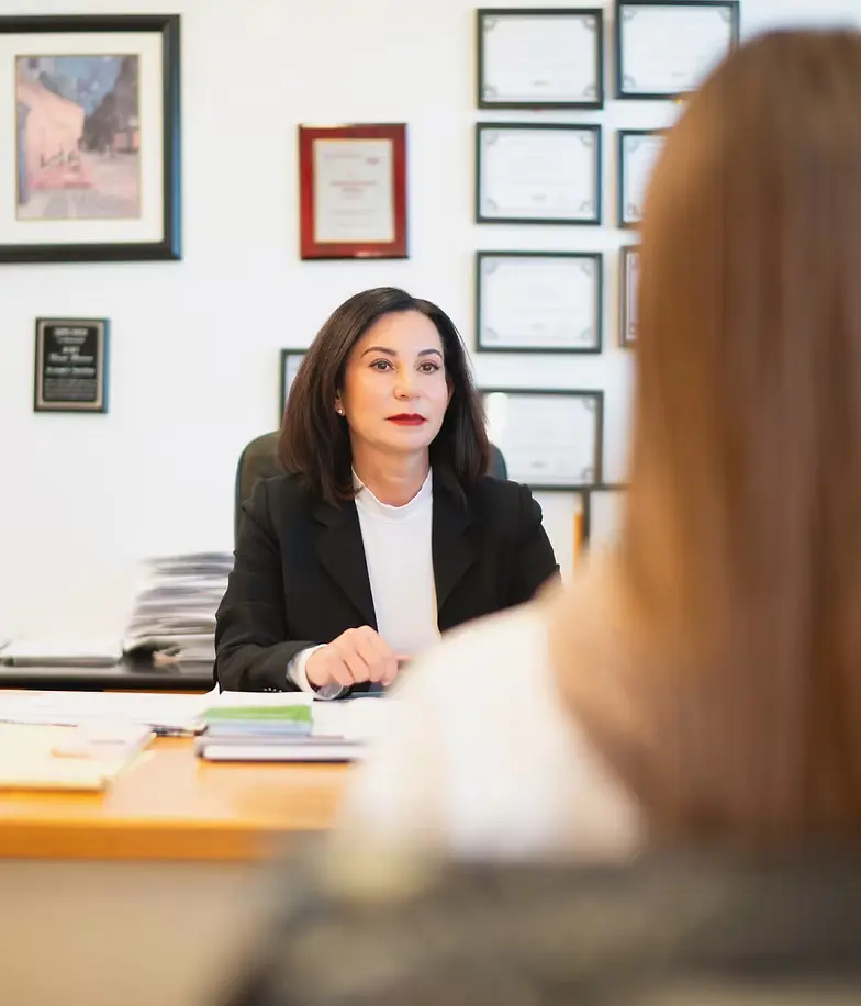 Lena Polnet, NMLS #17225, meeting a borrower at the Dynamic Funding Solutions office in Huntingdon Valley, PA, with the company licenses framed on the wall