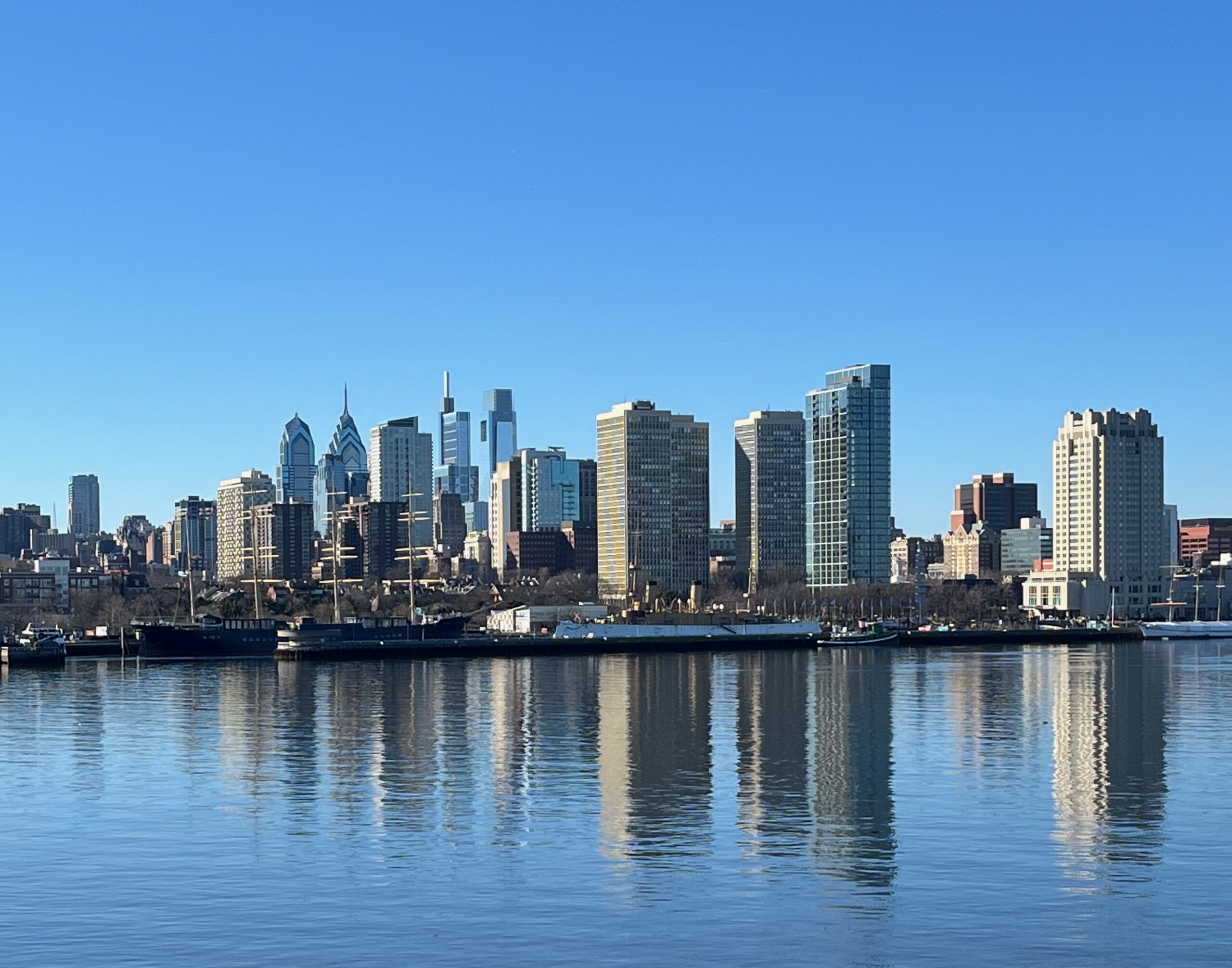 Philadelphia skyline viewed from the Camden waterfront, showing the city's landmark buildings across the Delaware River